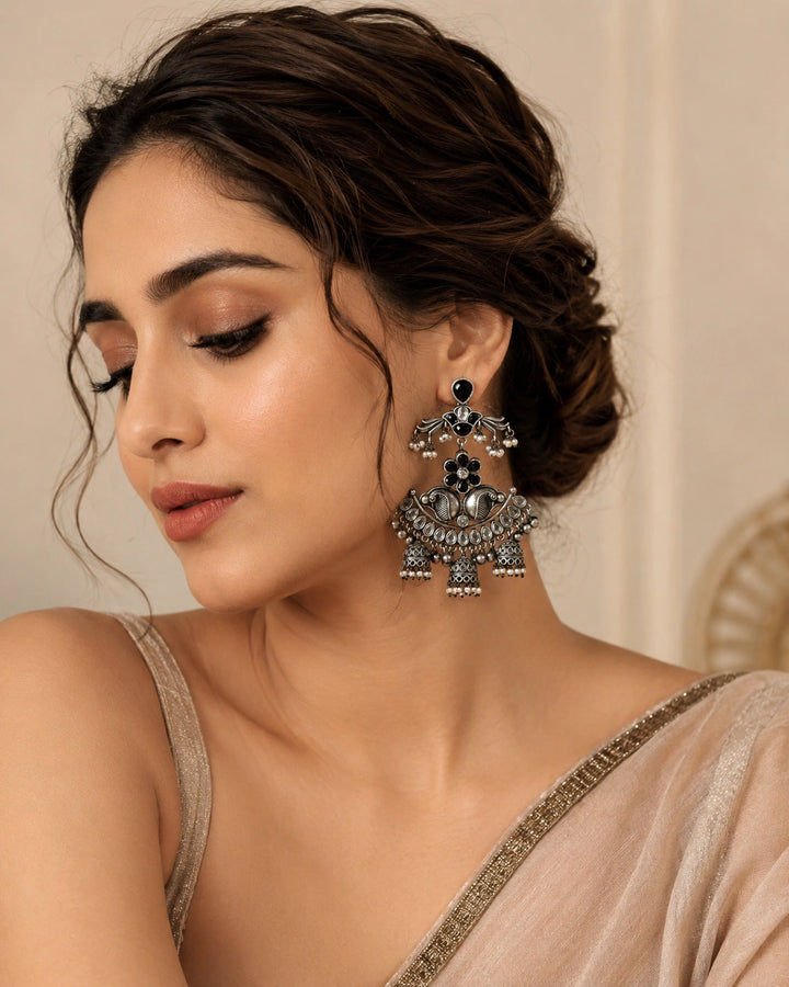 Antique German silver black pearl-style chandelier earrings worn by a model
