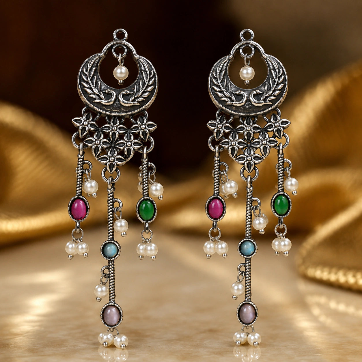 Multicolor pearl chandelier earrings on a dark jewellery studio display