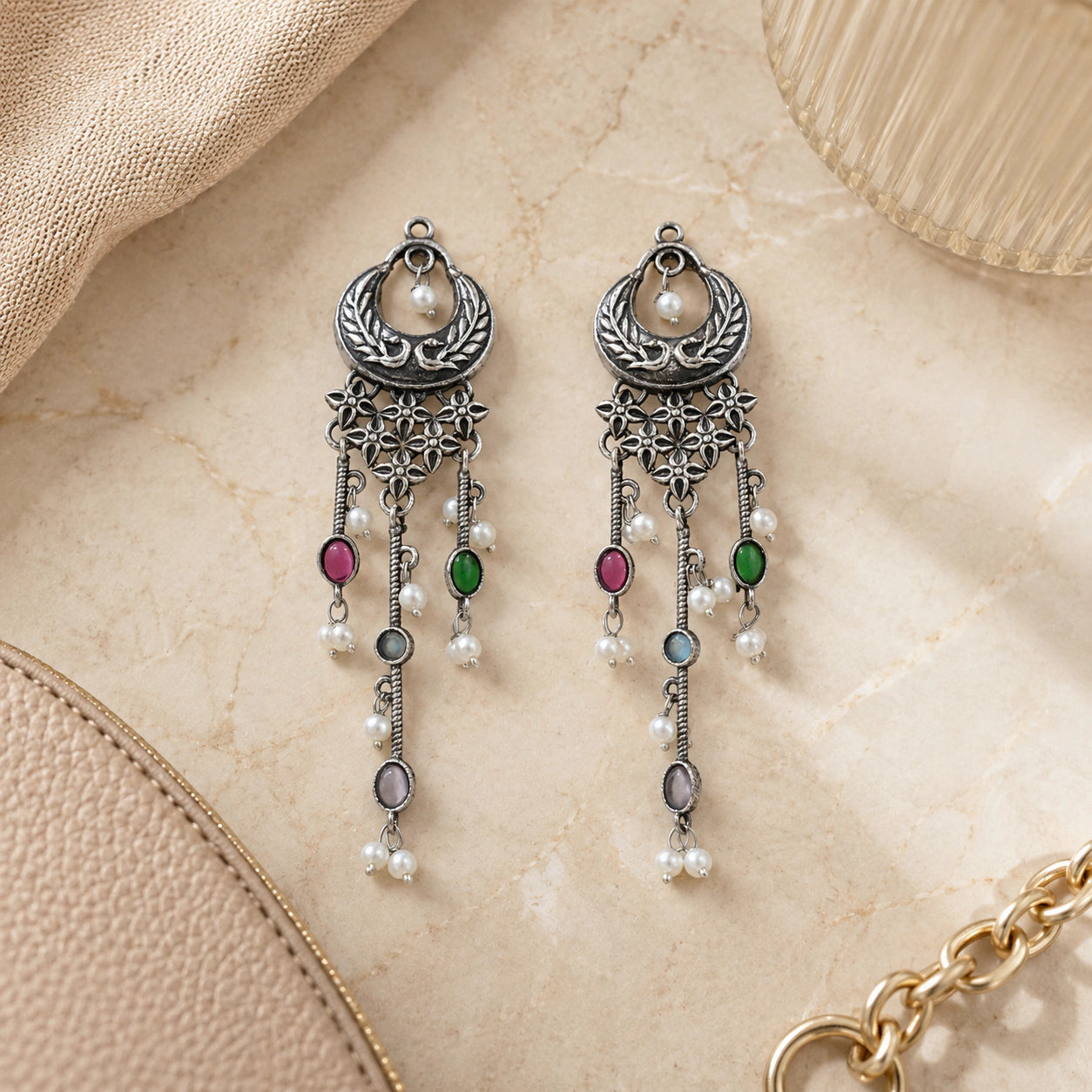 Multicolor pearl chandelier earrings styled in an elegant jewellery flat lay