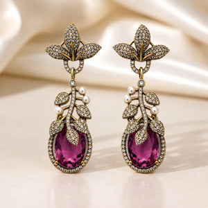 Angled view of antique gold purple leaf chandelier earrings