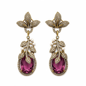 Antique gold purple leaf earrings on a dark jewellery studio display