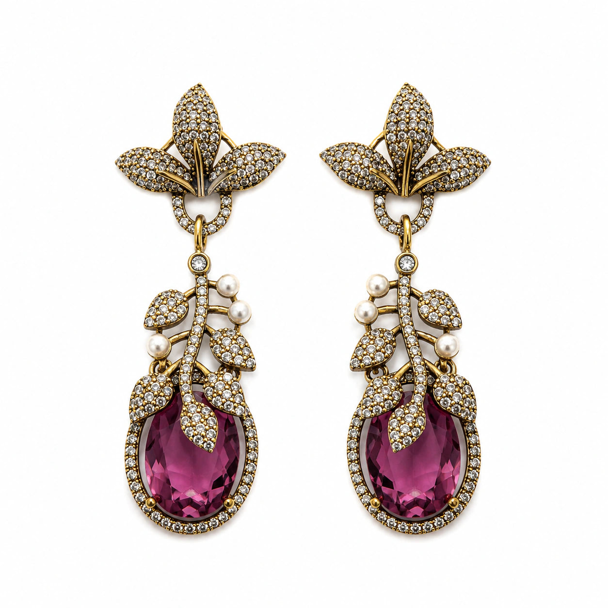 Antique gold purple leaf earrings on a dark jewellery studio display