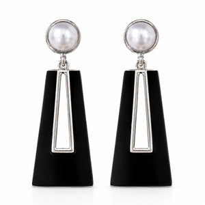 Close-up of black geometric forms and pearl-style drops