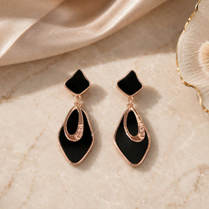 Black rose-gold geometric earrings styled in a modern jewellery flat lay