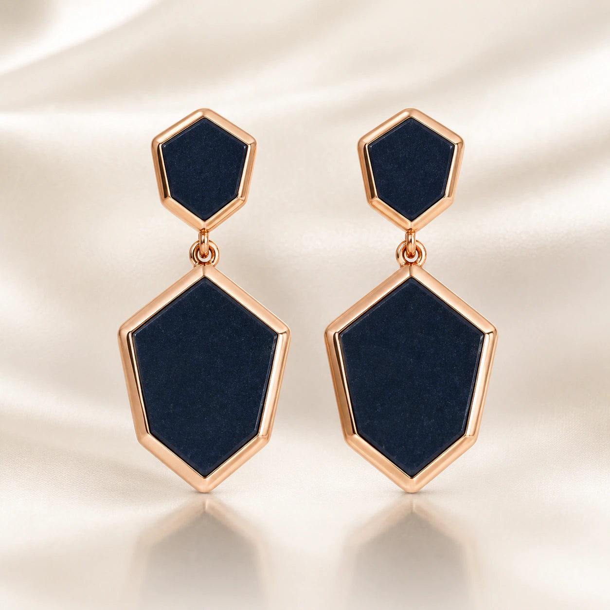 Black rose-gold geometric earrings on a dark jewellery studio display