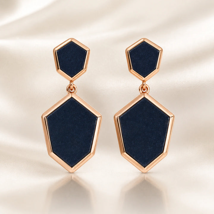 Black rose-gold geometric earrings on a dark jewellery studio display