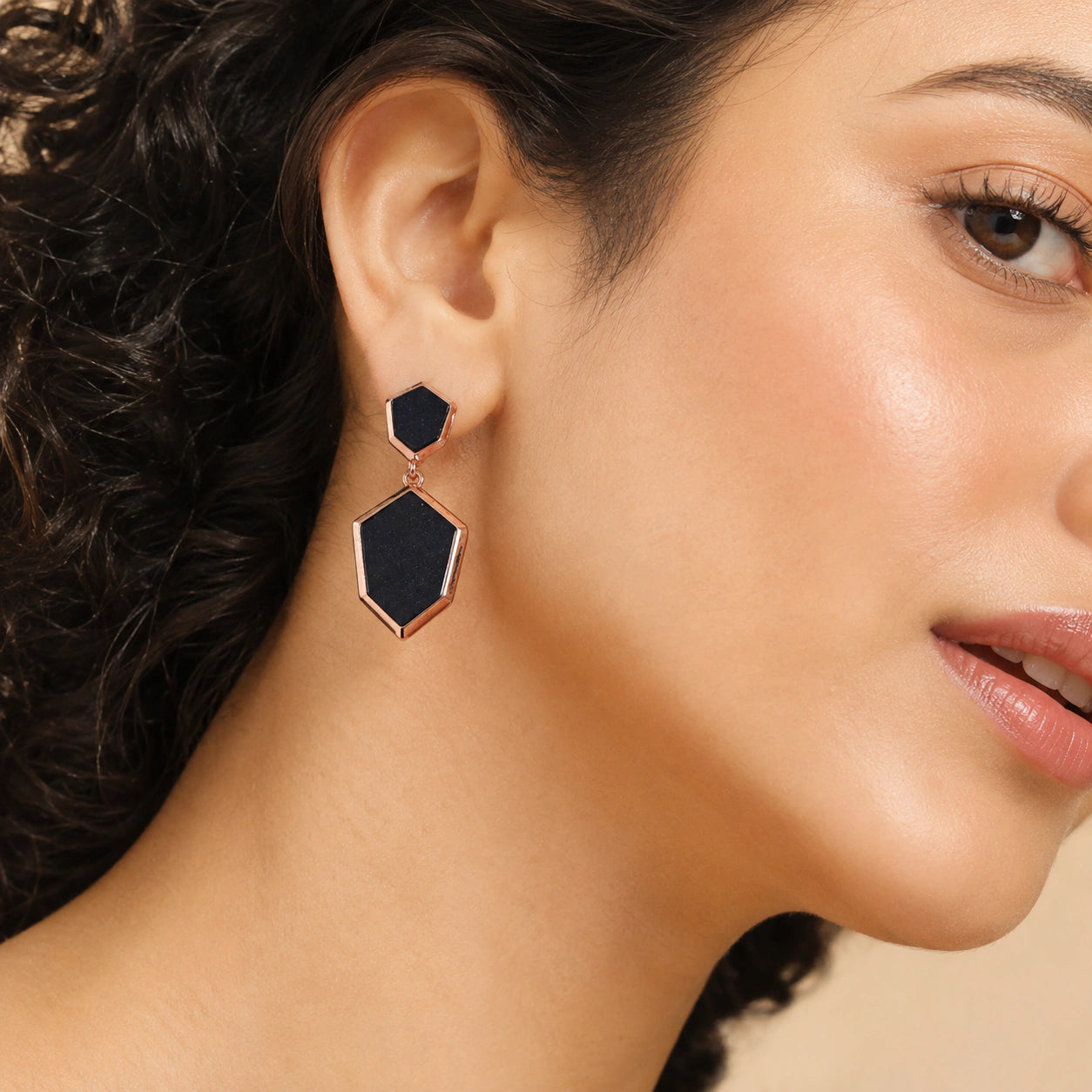 Black rose-gold geometric earrings styled in a modern jewellery flat lay
