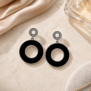 Black silver open-centre hoops styled in a modern jewellery flat lay