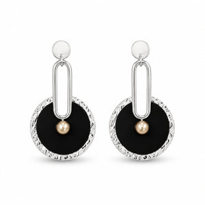 Black silver pearl statement earrings on a dark jewellery studio display