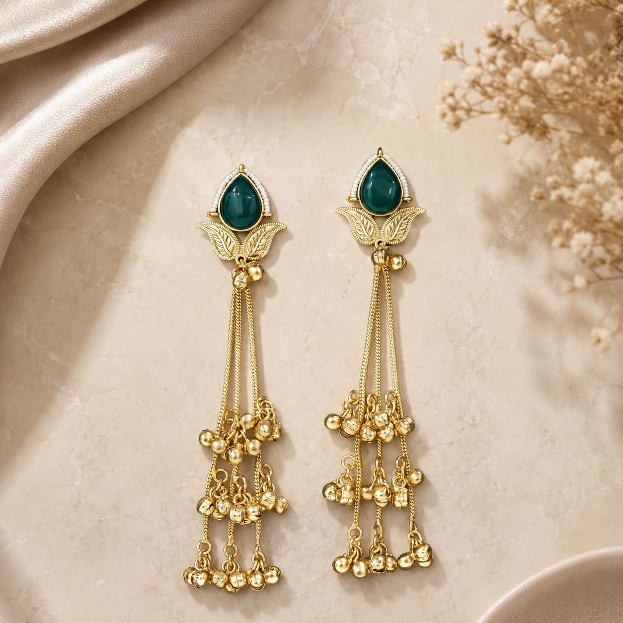 Close-up ear view showing green stones and layered pearl chandelier drops