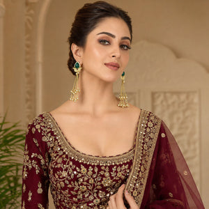 Close-up of green Kundan-style stones, pearl accents and brass-gold chandelier detailing