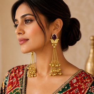 Angled view of brass-gold maroon Kundan pearl chandelier earrings