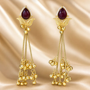 Close-up of maroon Kundan-style stones, pearls and brass-gold chandelier detailing