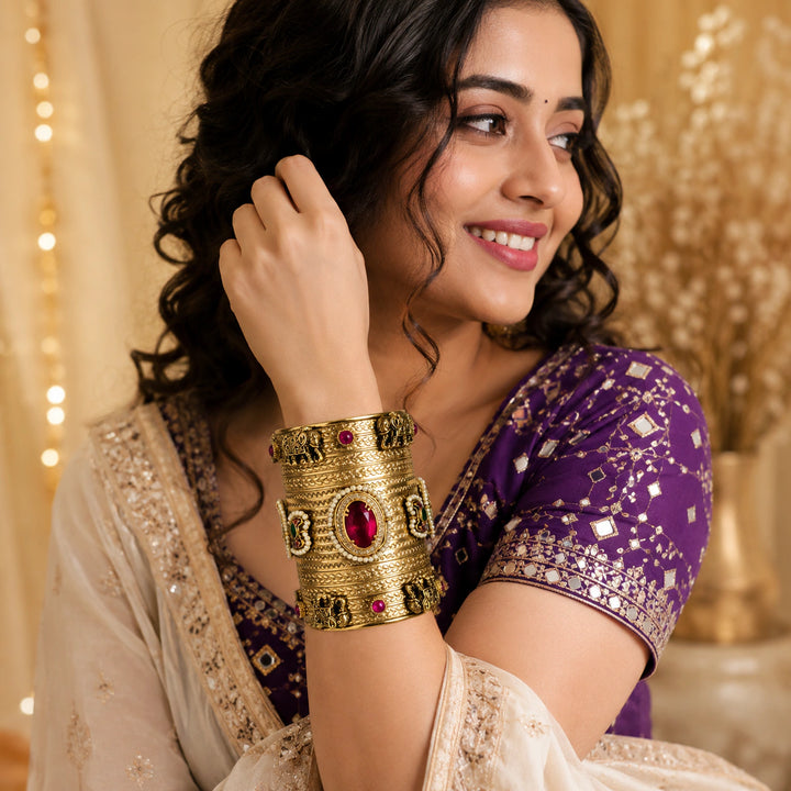 Elephant-motif red Kundan handwork kada on a dark jewellery studio display