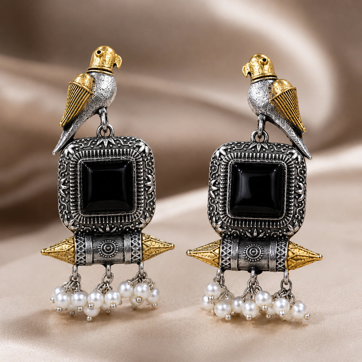 Angled view of German silver black-stone bird pearl-style earrings