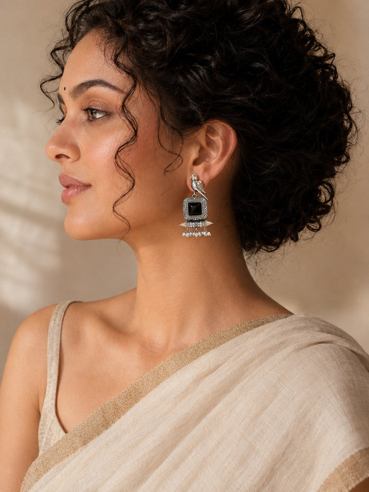 German silver black-stone bird pearl-style earrings worn by a model