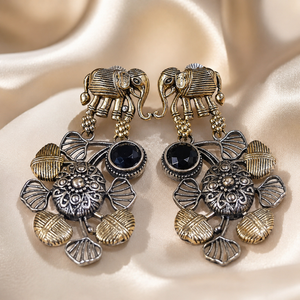 Angled view of German silver elephant black-stone chandelier earrings