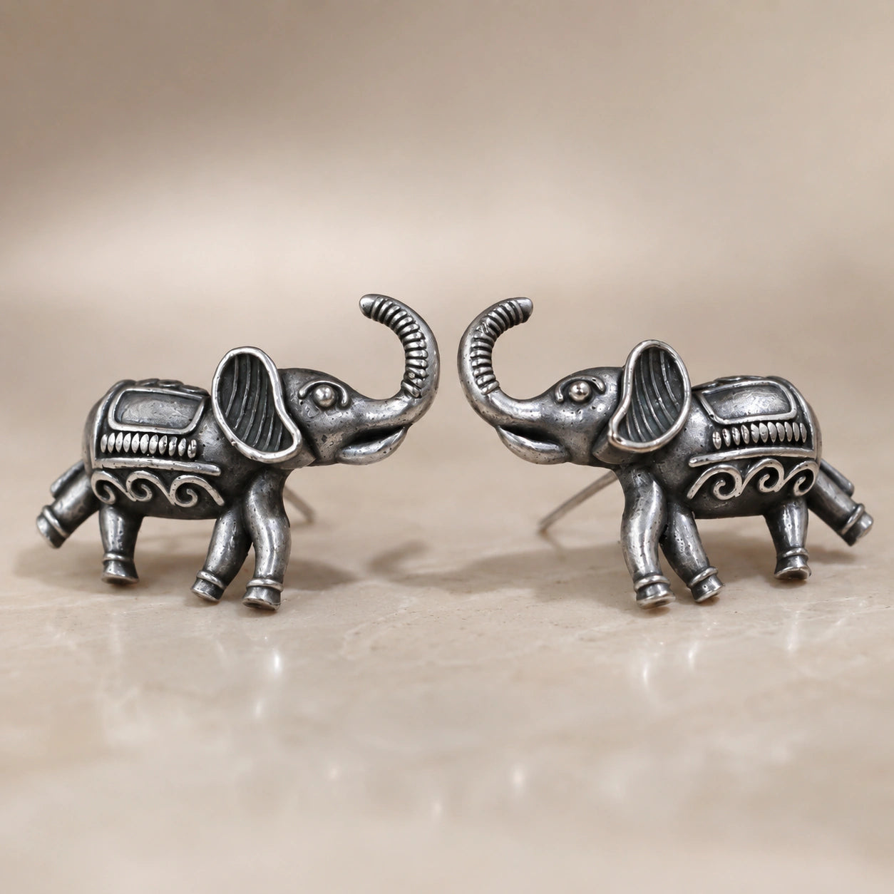 Angled view of German silver antique elephant stud earrings