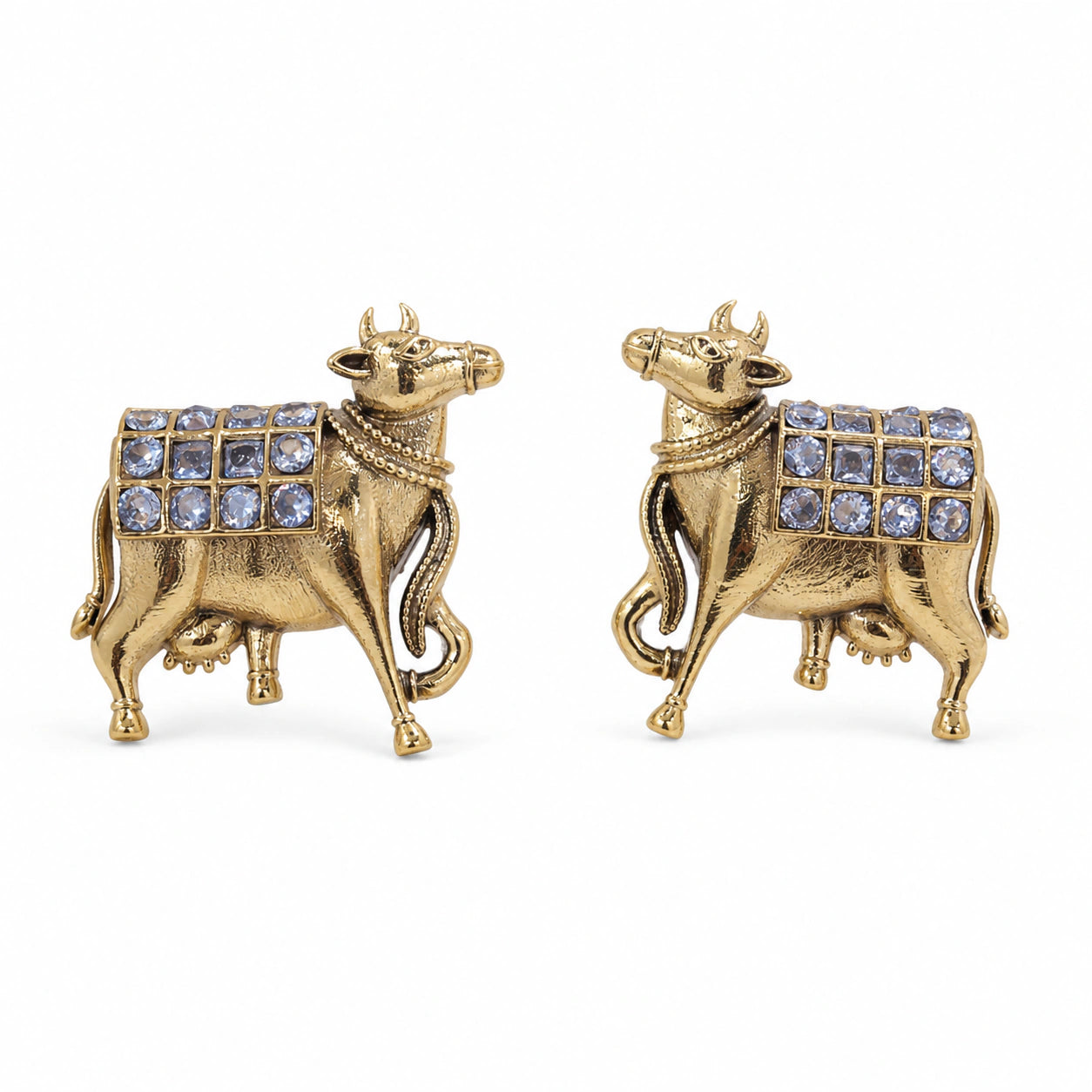 Angled view of German silver gold cow-motif crystal drop earrings