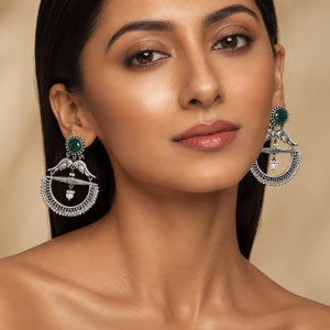 Green bird pearl chandelier earrings styled in an elegant jewellery flat lay