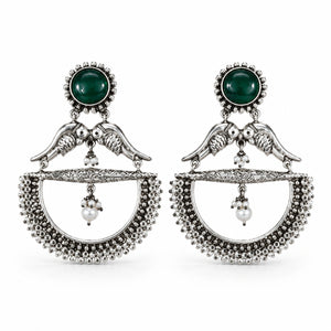 Close-up of green accents, bird motifs and pearl chandelier detailing