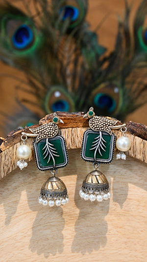 Close-up ear view showing green bird motifs and pearl-style jhumka drops
