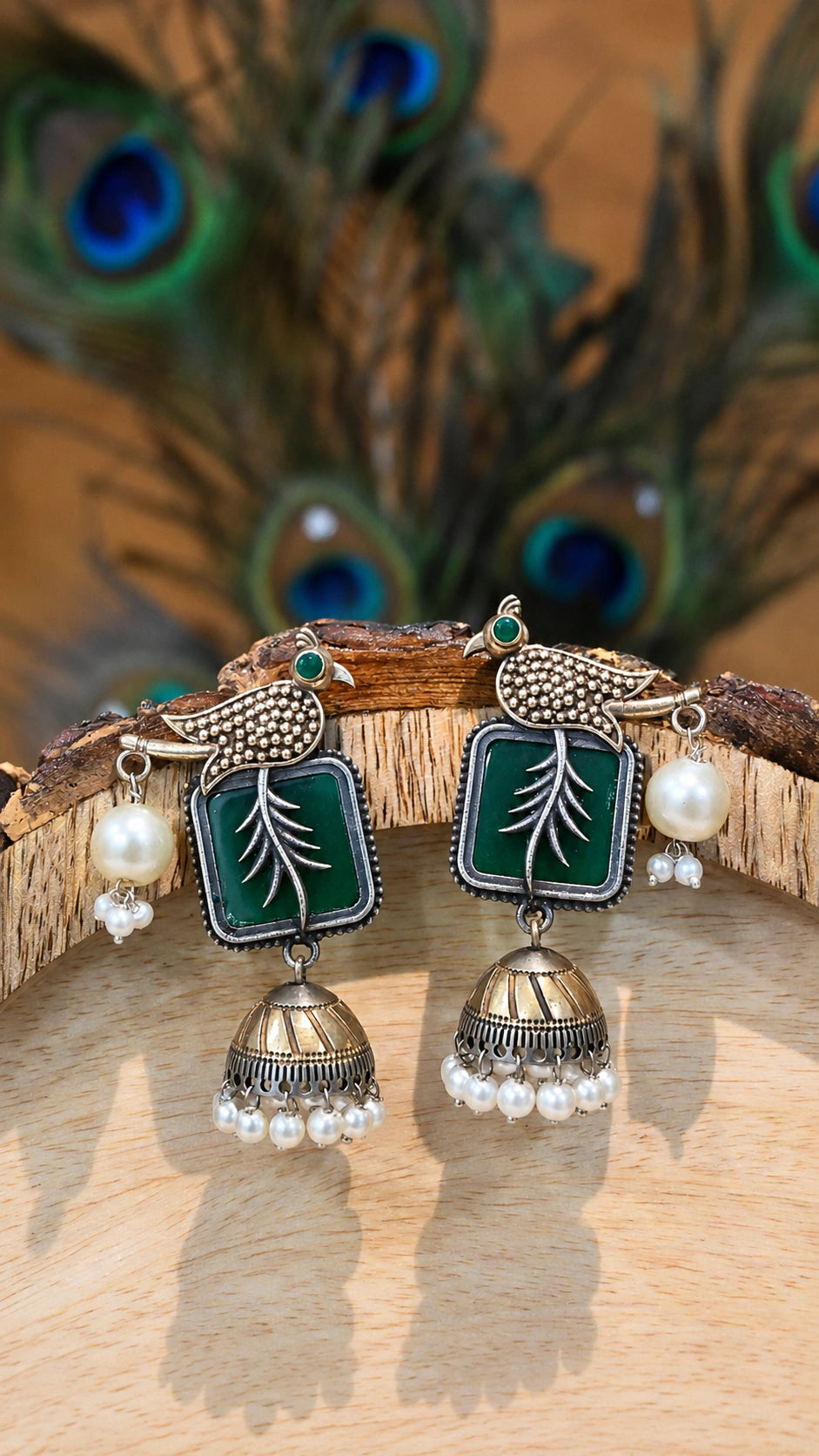 Close-up ear view showing green bird motifs and pearl-style jhumka drops