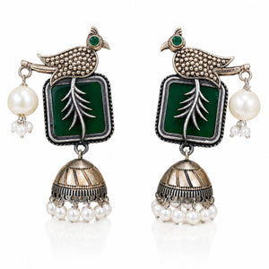 Close-up of green accents, engraved bird motifs and pearl jhumka detailing