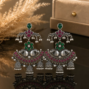 Green maroon pearl chandelier earrings on a dark jewellery studio display
