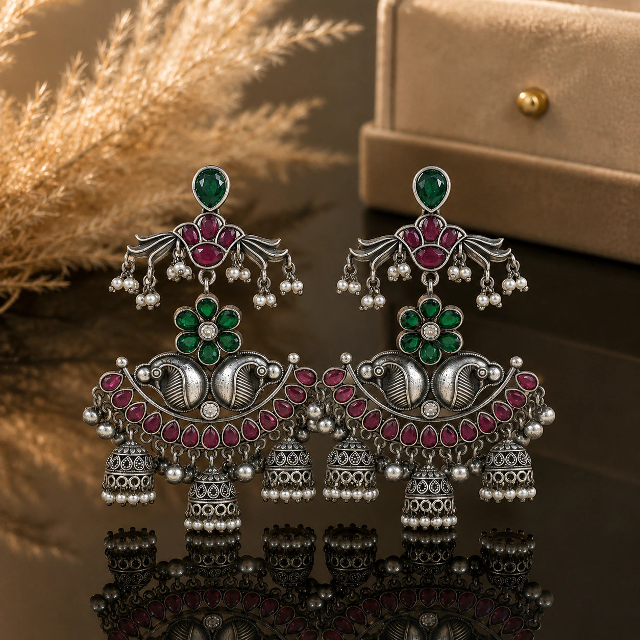 Green maroon pearl chandelier earrings on a dark jewellery studio display