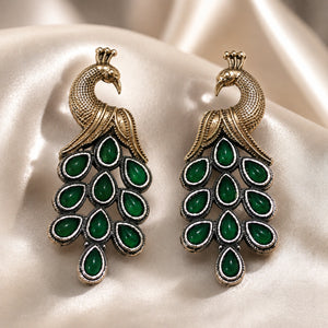 Angled view of German silver green peacock chandelier earrings