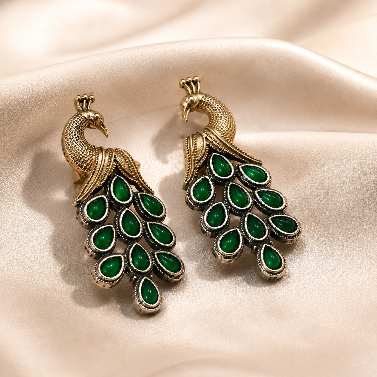 German silver green peacock chandelier earrings styled in a jewellery flat lay