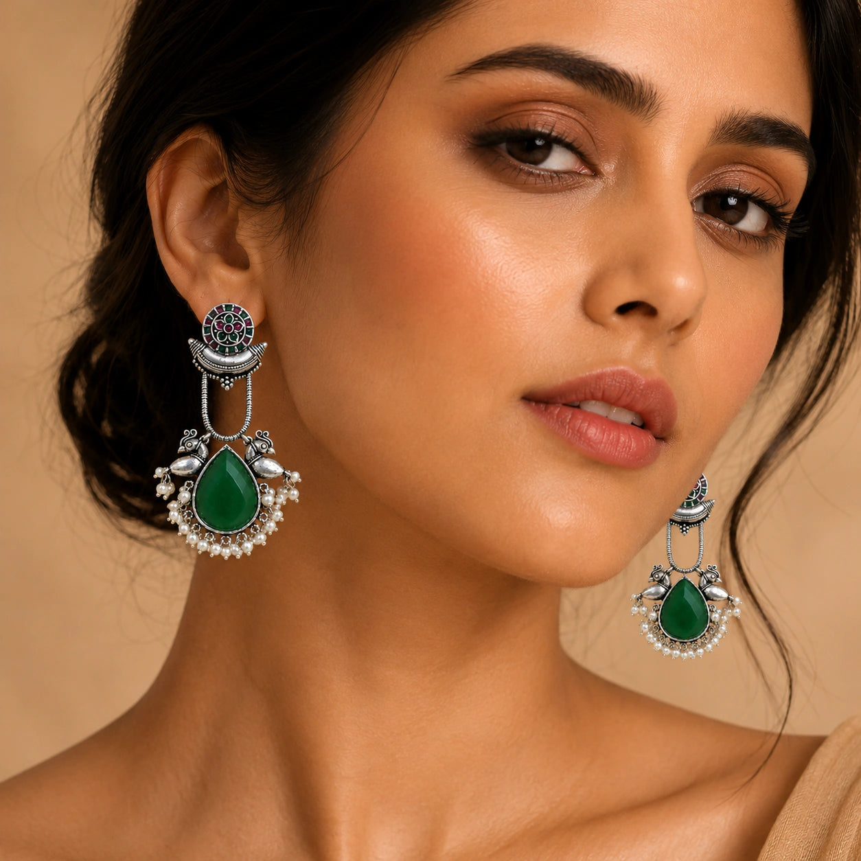 Angled view of German silver green pearl-style bird-motif earrings