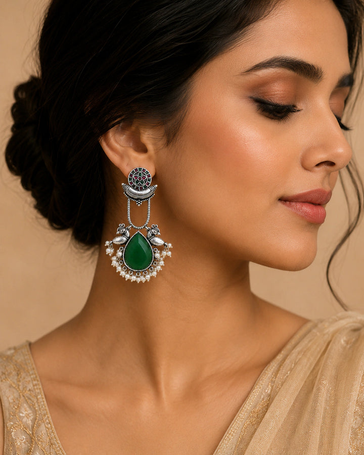 German silver green pearl-style bird-motif dangle earrings worn by a model