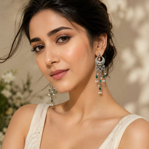 Angled view of German silver green pearl-style chandelier earrings