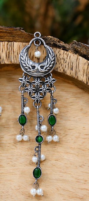 Close-up ear view showing green accents and layered pearl-style drops