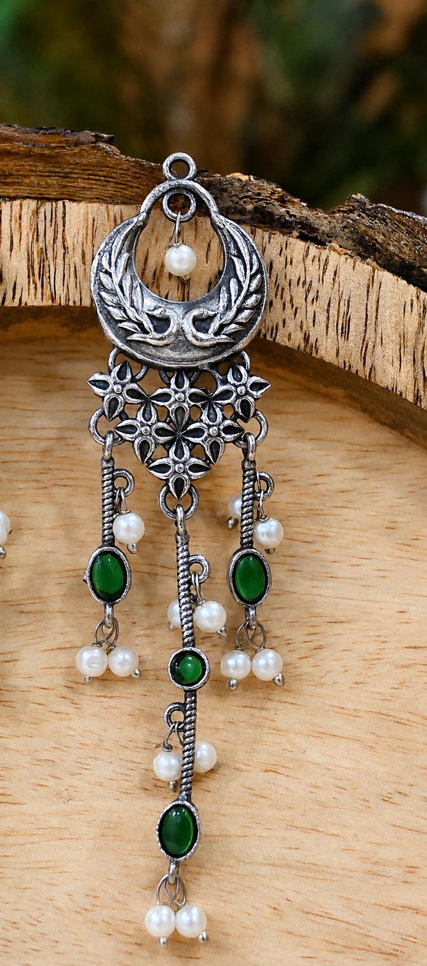 Close-up ear view showing green accents and layered pearl-style drops