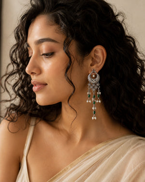 German silver green pearl-style chandelier earrings worn by a model
