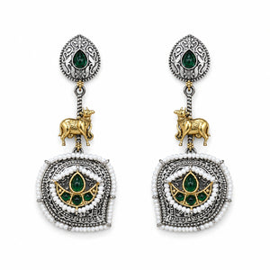 Angled view of German silver green pearl-style cow-motif earrings