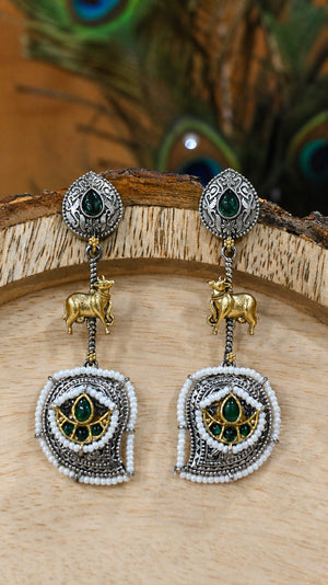 Close-up ear view showing green accents, cow motifs and pearl-style drops