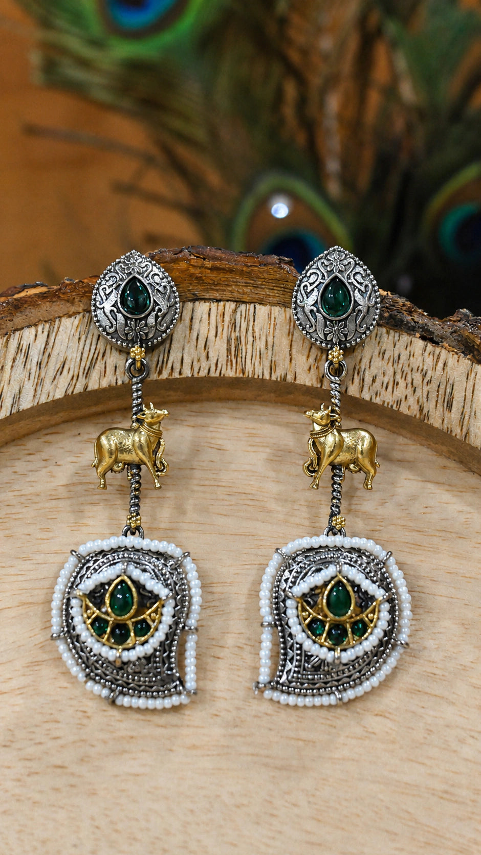 Close-up ear view showing green accents, cow motifs and pearl-style drops