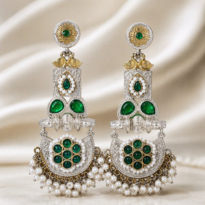 Green pearl peacock chandelier earrings styled in an elegant jewellery flat lay