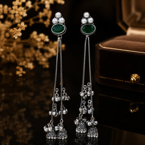 Green pearl tassel dangle earrings on a glossy dark jewellery display