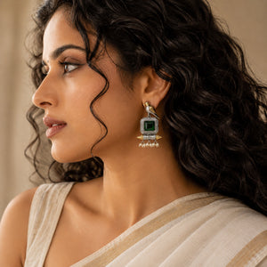 Close-up of green stones, bird motifs and pearl-style dangle detailing