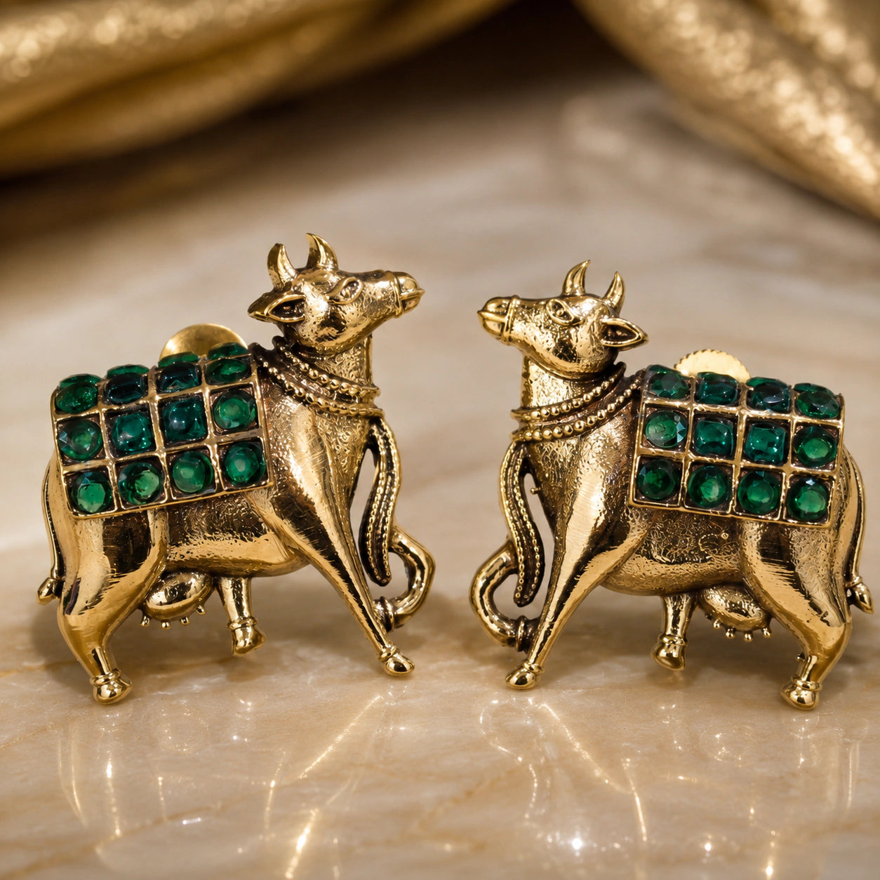 Angled view of German silver green-stone cow-motif earrings