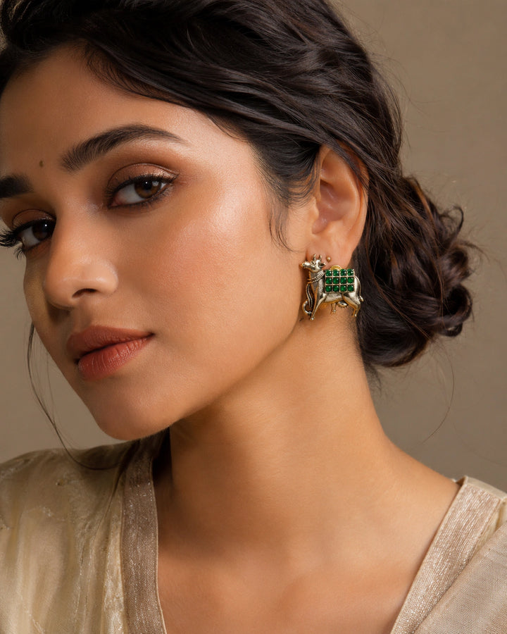 German silver green-stone cow-motif earrings worn by a model