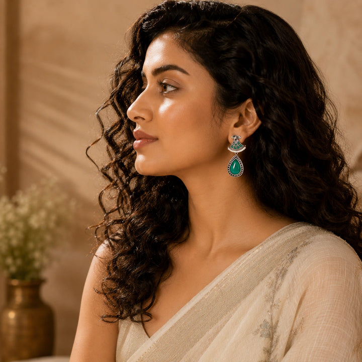 Close-up of green stones, pearl-style beads and German silver dangle detailing