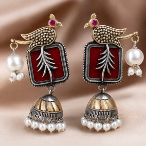 Maroon bird pearl jhumka earrings styled in an elegant jewellery flat lay