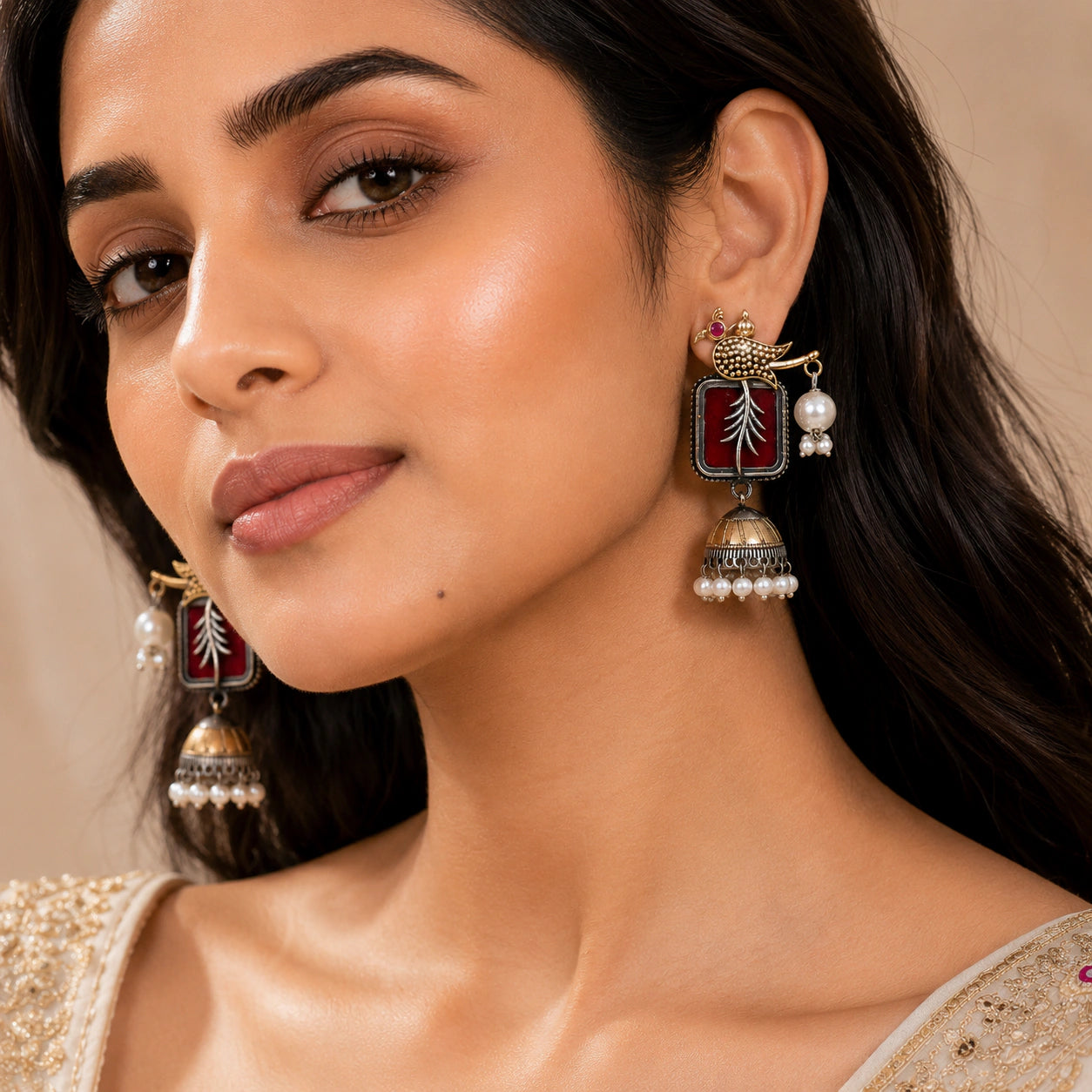 Close-up of maroon accents, engraved bird motifs and pearl jhumka detailing