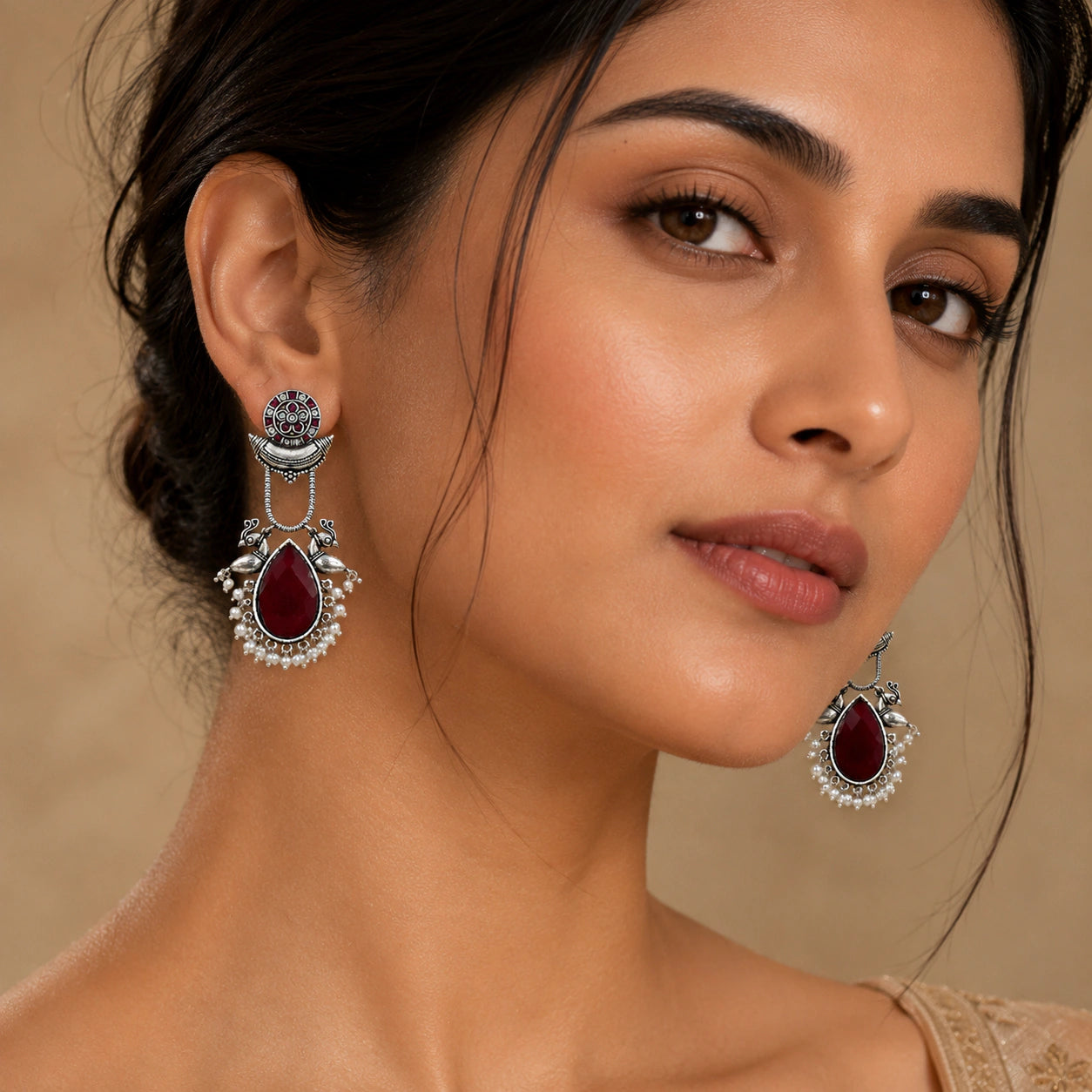 Angled view of German silver maroon pearl bird-motif dangle earrings